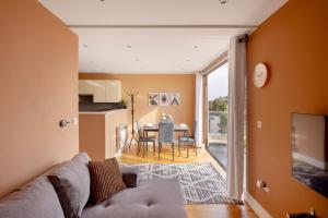 a living room with a couch and a table at Charming One-Bedroom Retreat in Kingston KT2, London in Kingston upon Thames