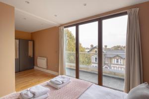 1 dormitorio con cama y ventana grande en Charming One-Bedroom Retreat in Kingston KT2, London en Kingston upon Thames