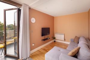 sala de estar con sofá y TV en Charming One-Bedroom Retreat in Kingston KT2, London en Kingston upon Thames