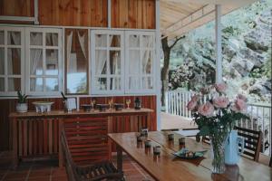 a kitchen with a wooden table with a vase of flowers at AROMA HOUSE - Private entire house on Cat Ba island in Cat Ba