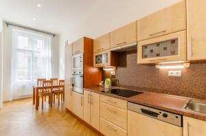 uma cozinha com armários de madeira e uma bancada em Historic Centre Apartments V em Praga