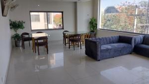 een woonkamer met een bank en een tafel en stoelen bij HOTEL MEDALLION EXPO in Lahore