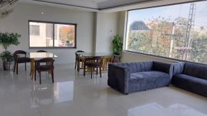 een woonkamer met een bank en een tafel en stoelen bij HOTEL MEDALLION EXPO in Lahore