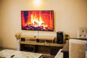 sala de estar con chimenea en la pared en R&R Cozy Homes Nakuru, en Nakuru