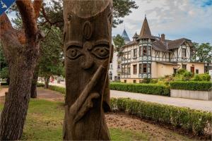 un poste de madera con una cara delante de una casa en Haus Ostseekristall Wohnung Smaragd, en Zinnowitz