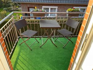 a table and chairs on a balcony with green grass at Ferienwohnung Lina in Westerstede in Westerstede