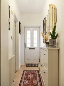 um corredor com uma porta branca e um tapete em Rofennie Suite -Brand new luxury ensuite room! em Maidstone