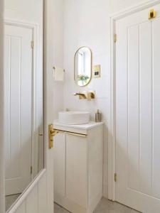 W białej łazience znajduje się umywalka i lustro. w obiekcie Rofennie Suite -Brand new luxury ensuite room! w mieście Maidstone