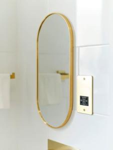 a mirror on a wall next to a lightswitch at Rofennie Suite -Brand new luxury ensuite room! in Maidstone