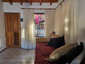 Un dormitorio con una cama y una ventana y una puerta. en La casa de Chiqui, en Mendoza