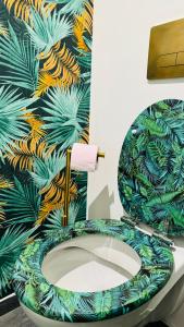 a bathroom with a toilet with a colorful wallpaper at Secret Garden in Roubaix +25 photos