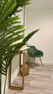 a desk and a green chair in a room at Secret Garden in Roubaix