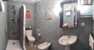 a bathroom with a sink and a toilet and a mirror at Hostal Rural Marques de Zahara in Zahara de la Sierra