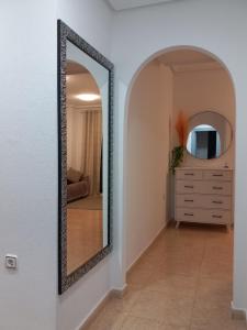 einen Spiegel an der Wand in einem Zimmer mit einer Kommode in der Unterkunft Olga`s Apartments, 300 Meter zu Playa del Cura in Torrevieja