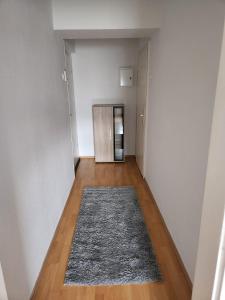 um corredor vazio com um tapete num piso de madeira em Wohnung HAMMer em Hamm