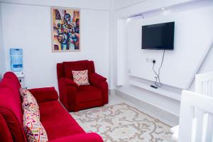 a living room with a red couch and a chair at Shanny's apartment in Eldoret