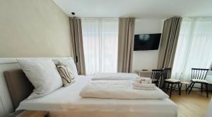 a bedroom with a large bed with white sheets at Strandhuus Norddeich in Norddeich