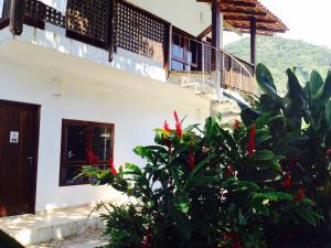 una casa con una escalera y una planta con flores rojas en Itamambuca Casa de Praia, en Ubatuba