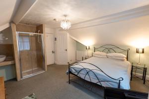 Un dormitorio con una cama y una ducha a ras de suelo. en Big Sky Guest House- ROOM ONLY, en Whitby