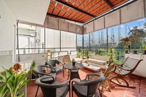 un balcone con sedie, tavoli e un divano di Cedar-Golf Course View a Bangalore