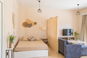 a bedroom with a bed and a couch and a tv at Casa Calida - 500m to Kos Town in Kaká Pinári