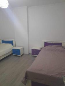 - une chambre avec 2 lits et 2 tables de chevet dans l'établissement Malena, à Pogradec