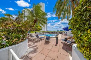 een patio met een tafel en stoelen en een zwembad bij Poolside Oasis in Miami