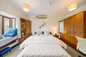una camera con un grande letto bianco e armadi in legno di Cedar-Golf Course View a Bangalore