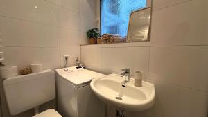 La salle de bains blanche est pourvue de toilettes et d'un lavabo. dans l'établissement Düsseldorf- Medienhafen Nähe Studio Apartment, à Düsseldorf
