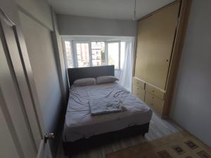 um pequeno quarto com uma cama e uma janela em Armutlu Dublex Apartment Seaside em Yalova
