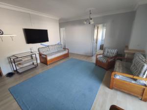 uma sala de estar com sofás e uma televisão de ecrã plano em Armutlu Dublex Apartment Seaside em Yalova