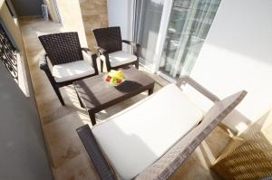 balkon z 2 krzesłami i stołem w obiekcie Stars Apartments w mieście Tivat