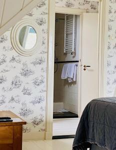 1 dormitorio con ducha y espejo en 't Heerenhuys en Wageningen