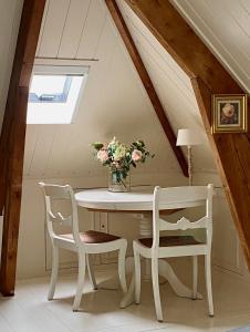 a table with two chairs and a vase of flowers at t Heerenhuys in Wageningen