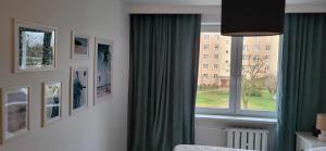 - une chambre avec une fenêtre et un rideau vert dans l'établissement Złotów 9, à Złotów