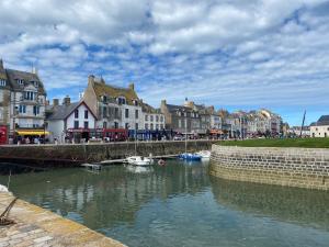einen Fluss mit Booten in einer Stadt mit Gebäuden in der Unterkunft Maison Guerande La Baule in Guérande