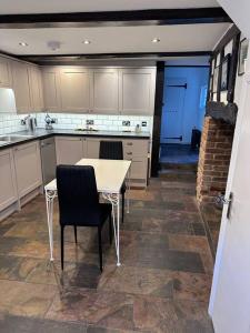 a kitchen with a table and two chairs in it at Characterful house in Hertford - near London in Hertford