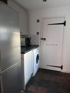 a kitchen with a refrigerator and a washing machine at Characterful house in Hertford - near London in Hertford