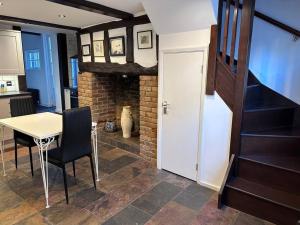 a kitchen and dining room with a table and a fireplace at Characterful house in Hertford - near London in Hertford