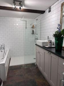a bathroom with a tub and a sink and a shower at Characterful house in Hertford - near London in Hertford