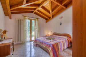 sypialnia z łóżkiem i drewnianym sufitem w obiekcie Casa Maddalena Private Beach on request - Happy Rentals w mieście Cadrezzate +26 zdjęć
