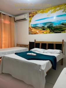 2 camas en una habitación con un cuadro en la pared en Hotel Novo Gama, en Novo Gama