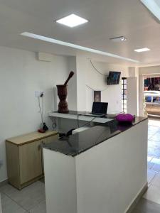 een keuken met een bureau en een laptop op een aanrecht bij Hotel Novo Gama in Novo Gama