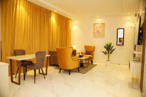 sala de estar con mesa y sillas en view Rose Hotel Apartment en Dammam