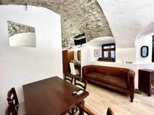 uma sala de estar com uma mesa e um sofá em Rifugio di Losine - Relax - Natura - Wi-Fi em Esine