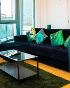 a blue couch with pillows on it in a living room at The Regency Suite - Modern 2-Bed 1-Bath Apartment in Chertsey