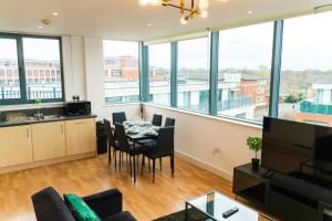 a living room with a table and chairs and windows at The Regency Suite - Modern 2-Bed 1-Bath Apartment in Chertsey