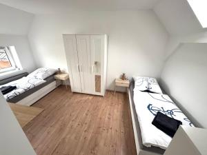 um pequeno quarto com duas camas e uma porta em Große Ferienwohnung in Ostseenähe em Schönberg