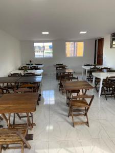 a room filled with wooden tables and benches at Hotel Novo Gama in Novo Gama