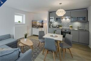a kitchen and living room with a table and chairs at Ahlbeck Remise Uppsala in Ahlbeck
